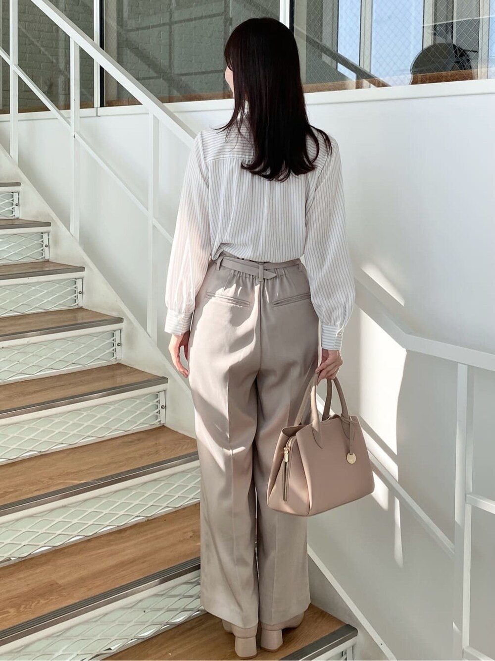ベージュ系のその他パンツ、ベージュ系のボストンバッグ、ベージュ系のブーツを着用したレディースの冬コーディネートの4枚目の写真