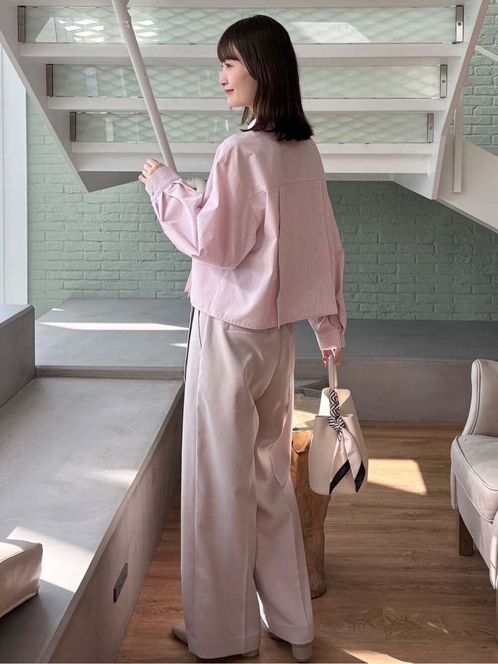ピンク系のシャツ/ブラウス、ベージュ系のその他パンツ、ホワイト系のトートバッグを着用したレディースの冬コーディネートの5枚目の写真