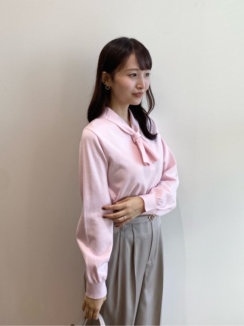 ピンク系のニット/セーター、ベージュ系のその他パンツ、ベージュ系のショルダーバッグを着用したレディースの冬コーディネートの7枚目の写真