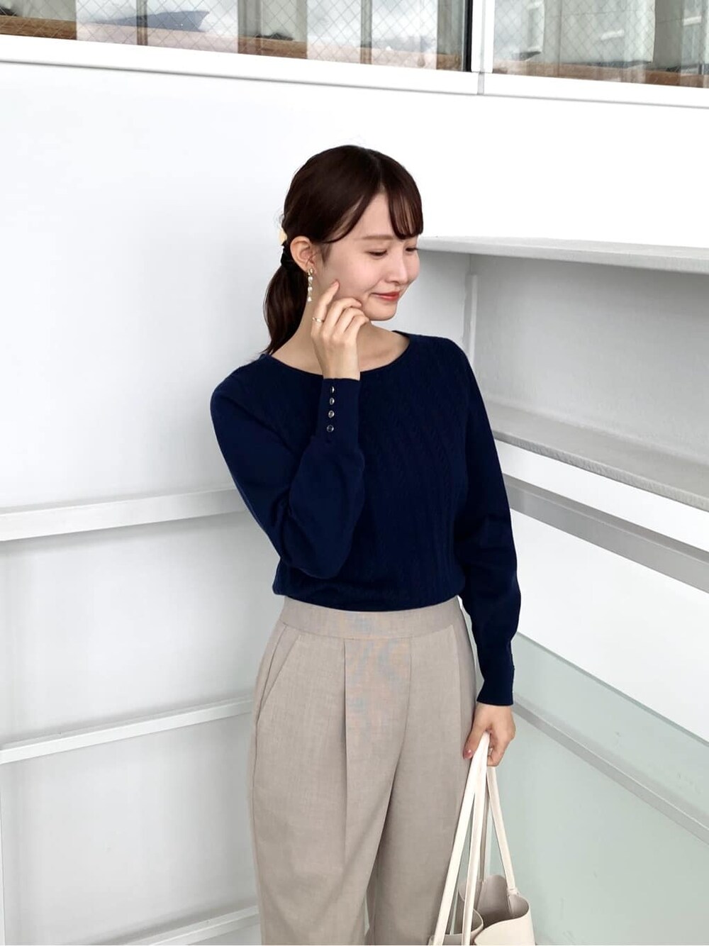 ブルー系のニット/セーター、ベージュ系のその他パンツ、ホワイト系のトートバッグを着用したレディースの秋コーディネートの7枚目の写真