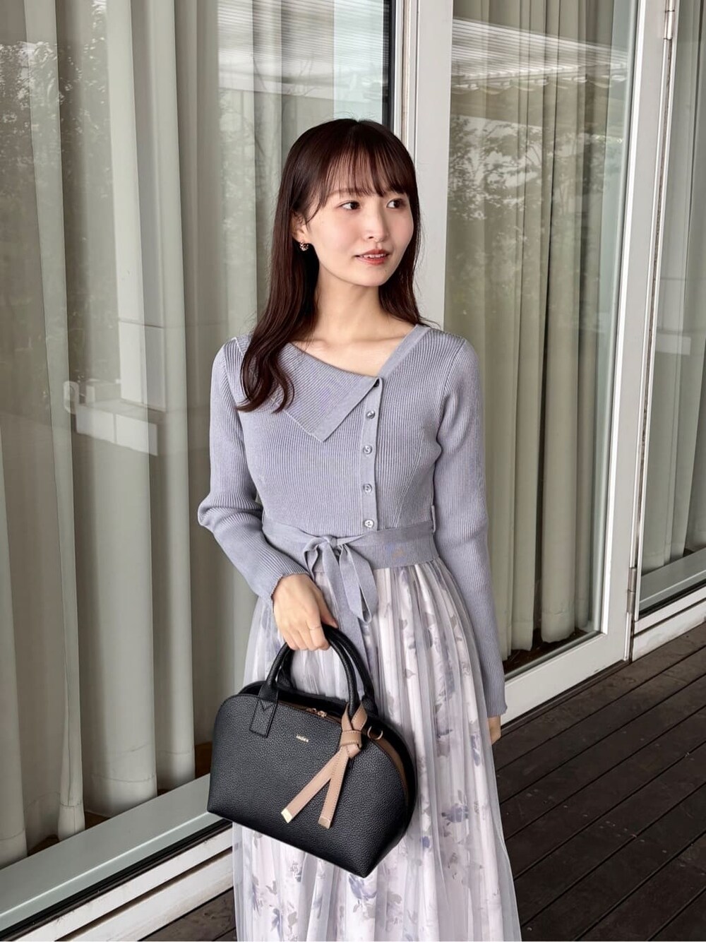 ブルー系のワンピース、ブラック系のボストンバッグ、ブラック系のパンプスを着用したレディースの冬コーディネートの6枚目の写真