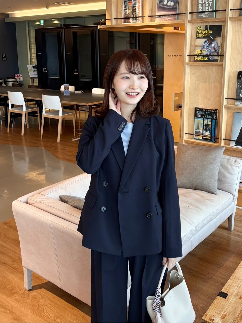 ブルー系のスカート、ブラック系のパンプス、ブルー系のニット/セーターを着用したレディースの春コーディネートの7枚目の写真
