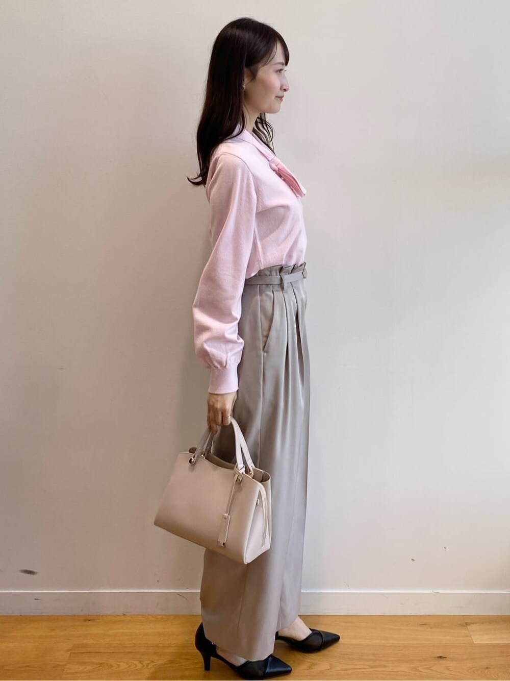 ピンク系のニット/セーター、ベージュ系のその他パンツ、ベージュ系のショルダーバッグを着用したレディースの冬コーディネートの3枚目の写真