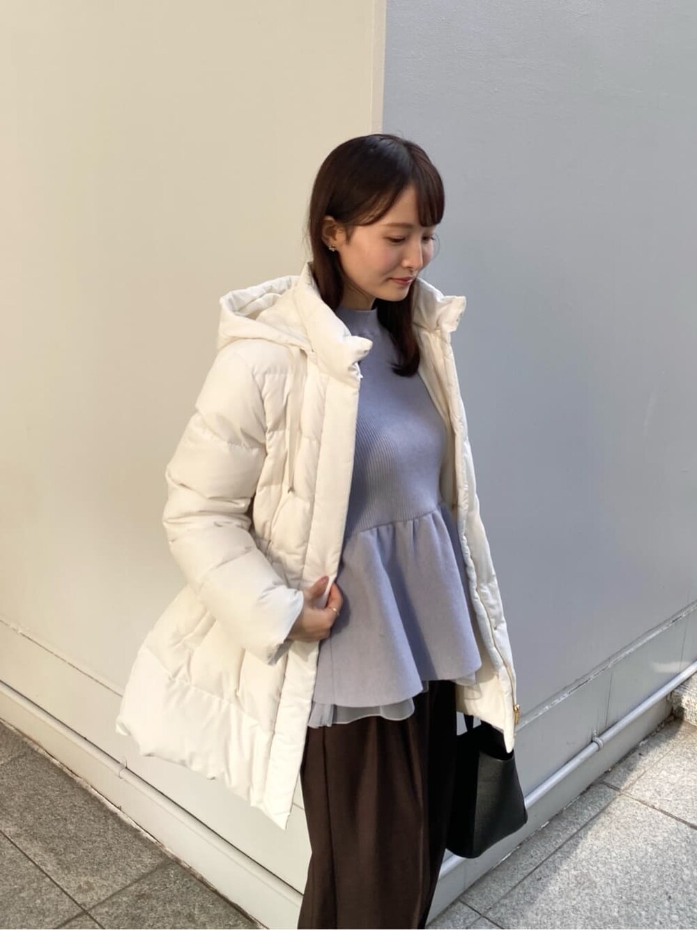 ベージュ系のダウンジャケット/コート、ブルー系のニット/セーター、ブラウン系のその他パンツを着用したレディースの冬コーディネートの6枚目の写真