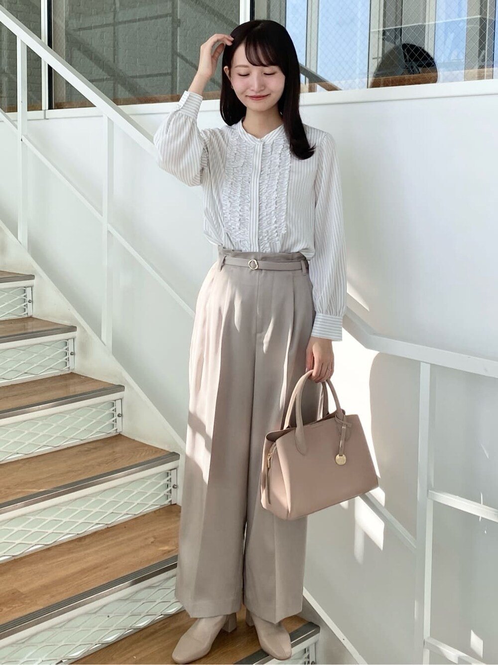ベージュ系のその他パンツ、ベージュ系のボストンバッグ、ベージュ系のブーツを着用したレディースの冬コーディネートの2枚目の写真