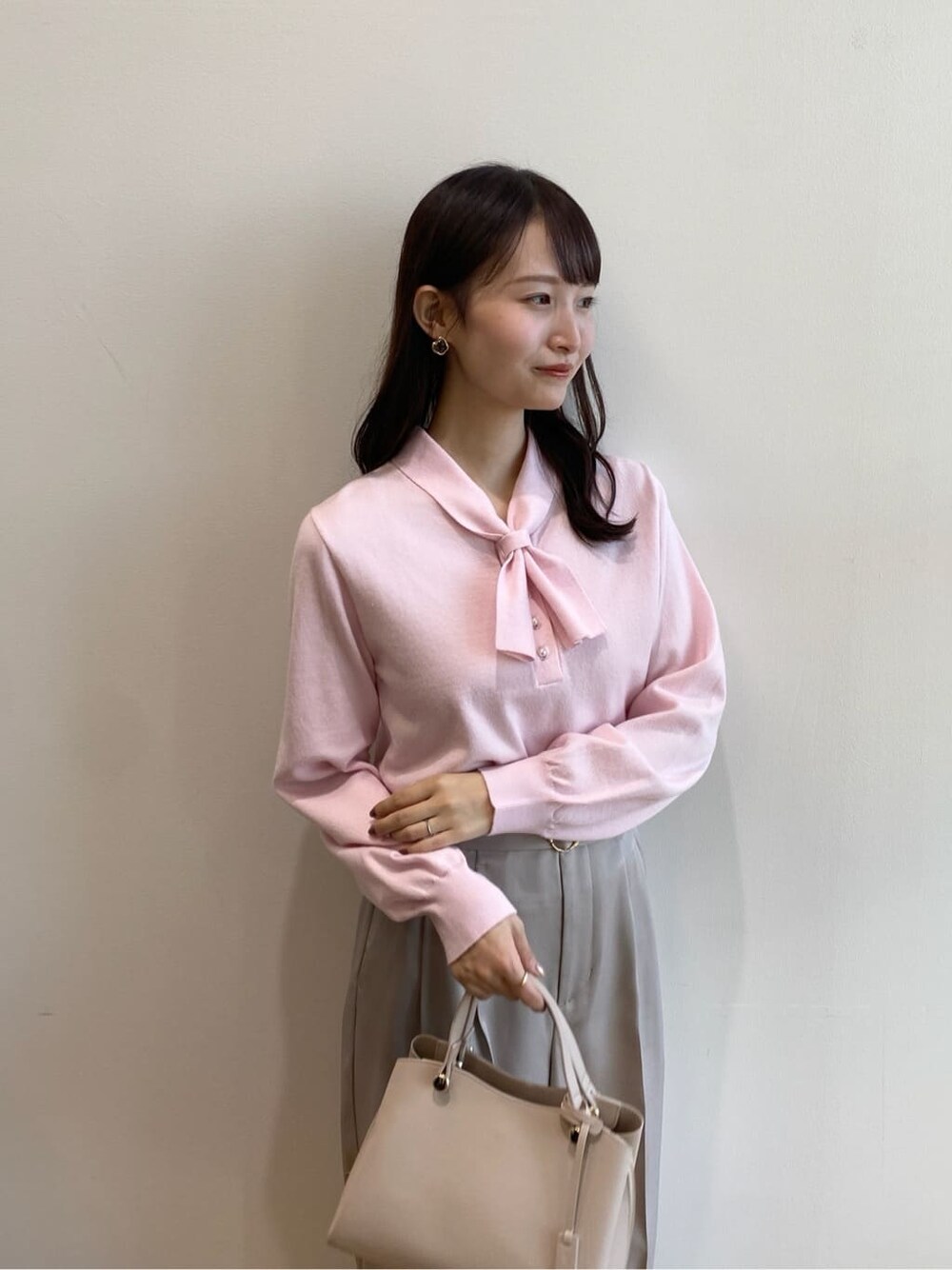 ピンク系のニット/セーター、ベージュ系のその他パンツ、ベージュ系のショルダーバッグを着用したレディースの冬コーディネートの6枚目の写真