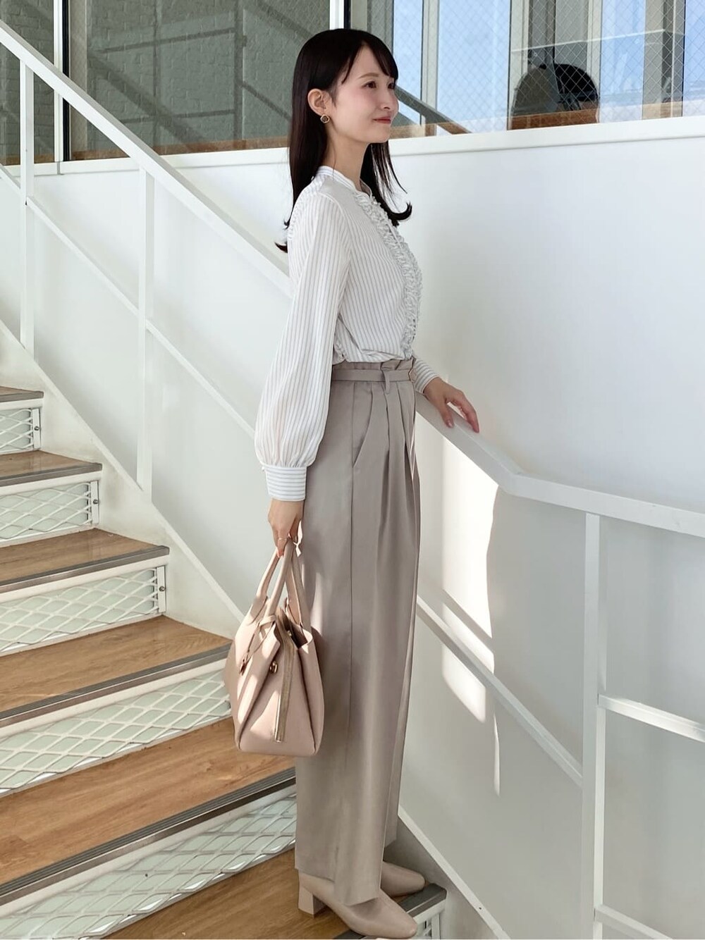 ベージュ系のその他パンツ、ベージュ系のボストンバッグ、ベージュ系のブーツを着用したレディースの冬コーディネートの3枚目の写真