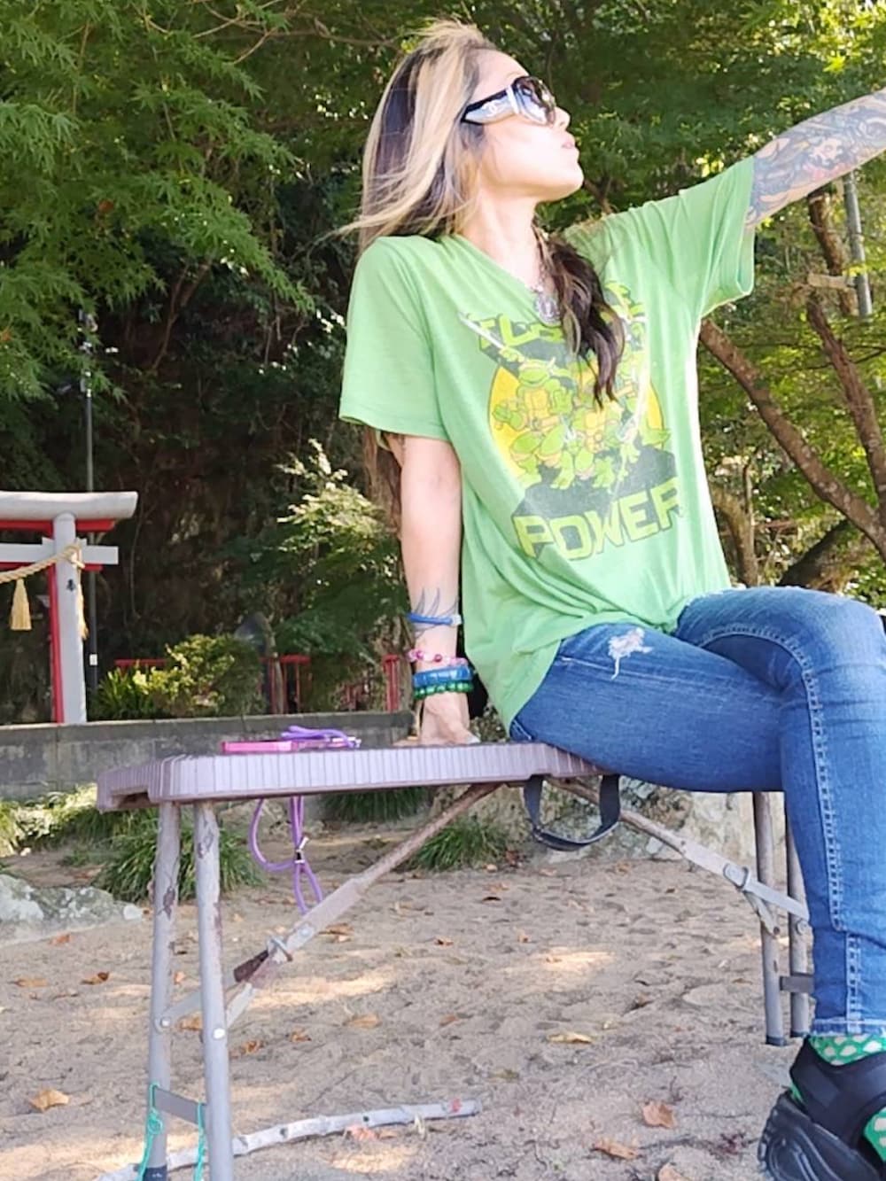 ブルー系のデニムパンツ、グリーン系のTシャツ/カットソーを着用したレディースの秋コーディネートの2枚目の写真