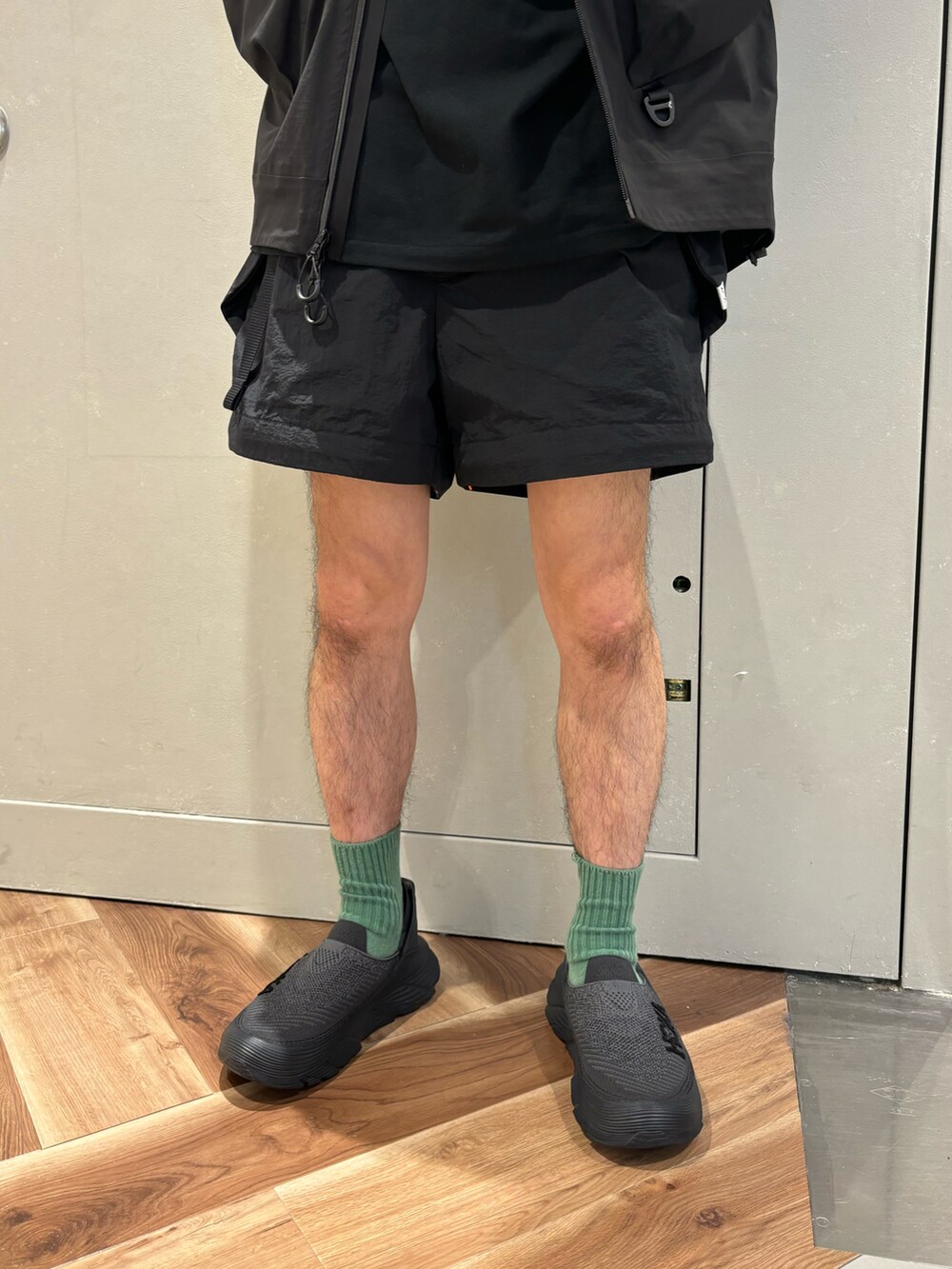 ブラック系のマウンテンパーカー、ブラック系のTシャツ/カットソー、ブラック系のその他パンツを着用したメンズの春コーディネートの3枚目の写真