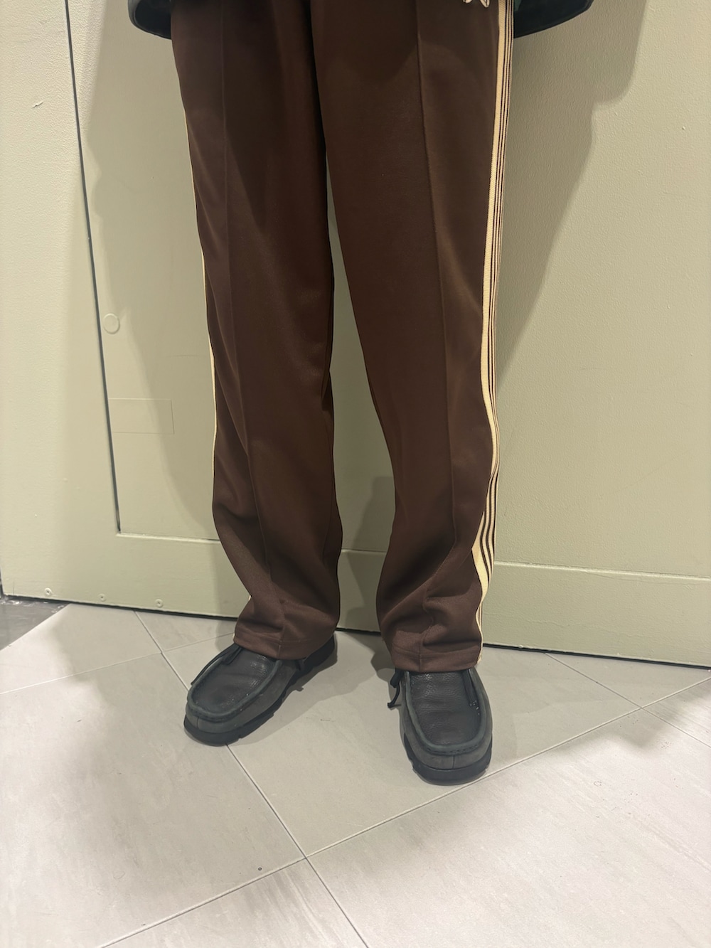 ブラック系のライダースジャケット、グリーン系のニット/セーター、ブラック系のモカシン/デッキシューズを着用したメンズの冬コーディネートの3枚目の写真