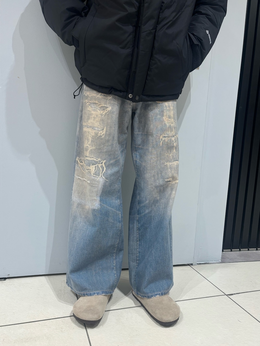 ブラック系のダウンジャケット/コート、その他のデニムパンツ、ベージュ系のサンダルを着用したメンズの冬コーディネートの6枚目の写真