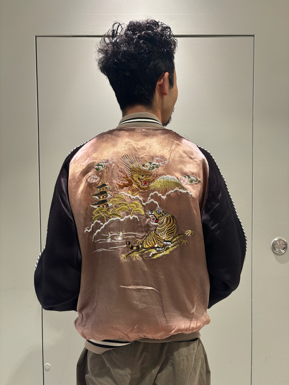 ベージュ系のスカジャン、ホワイト系のTシャツ/カットソー、ブラック系のモカシン/デッキシューズを着用したメンズの冬コーディネートの3枚目の写真