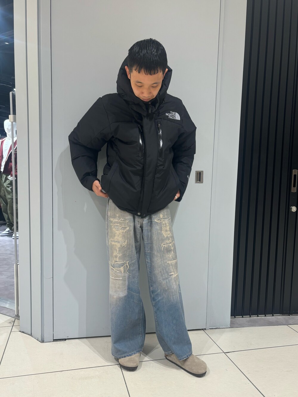 ブラック系のダウンジャケット/コート、その他のデニムパンツ、ベージュ系のサンダルを着用したメンズの冬コーディネートの2枚目の写真