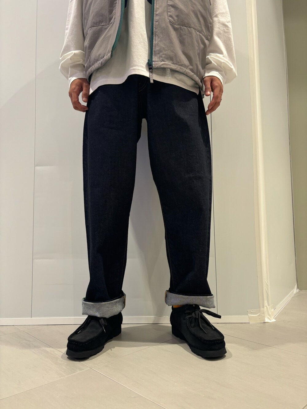 ホワイト系のTシャツ/カットソー、ブルー系のデニムパンツ、ブラック系のモカシン/デッキシューズを着用したメンズの秋コーディネートの3枚目の写真