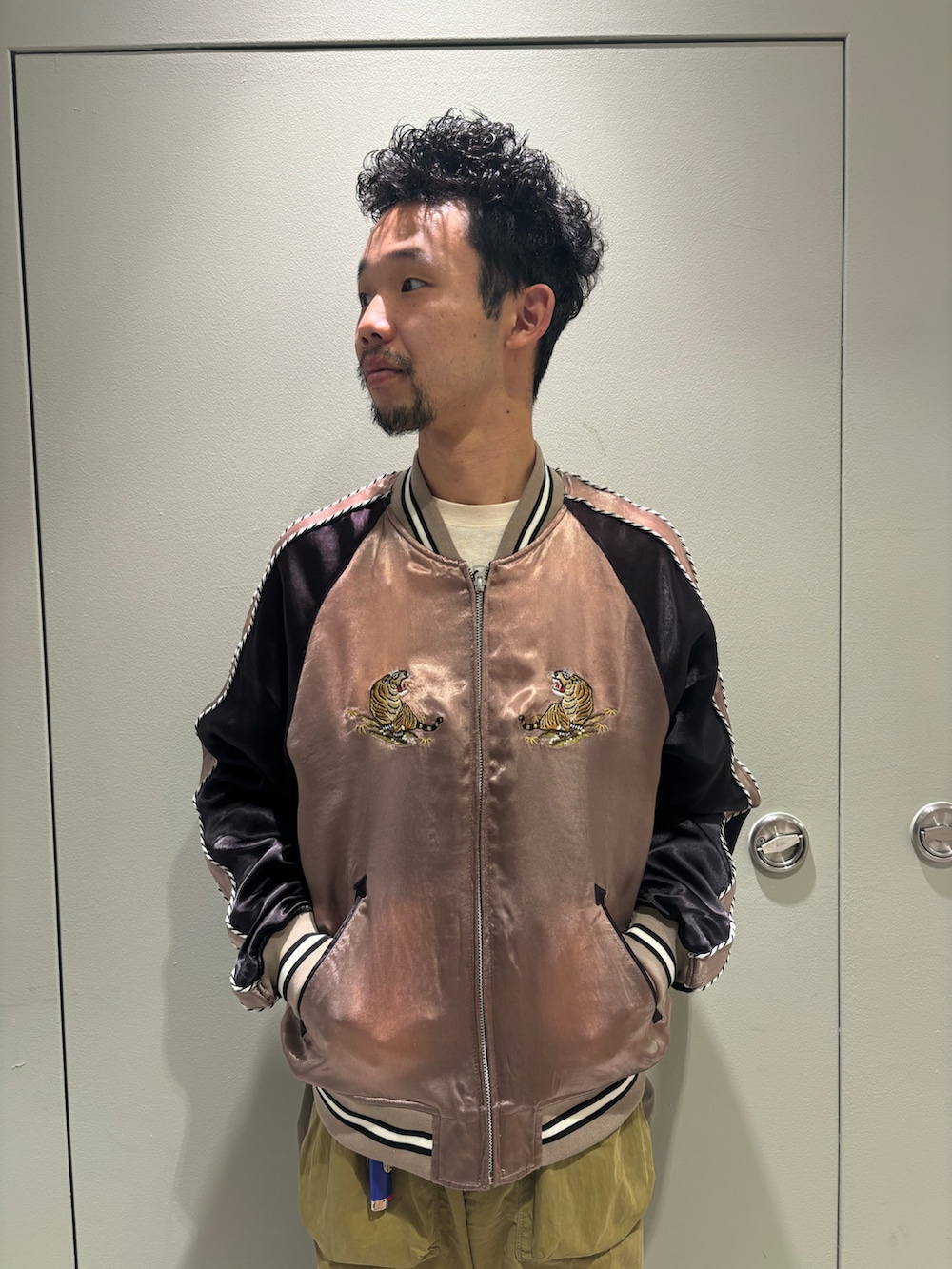 ベージュ系のスカジャン、ホワイト系のTシャツ/カットソー、ブラック系のモカシン/デッキシューズを着用したメンズの冬コーディネートの2枚目の写真