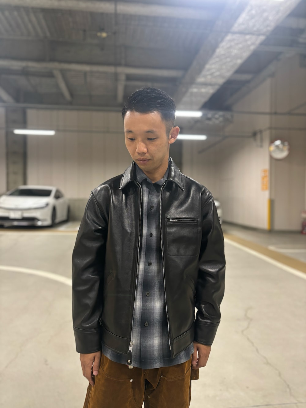 ブラック系のライダースジャケット、ブラック系のシャツ/ブラウス、ブラウン系のデニムパンツを着用したメンズの秋コーディネートの2枚目の写真