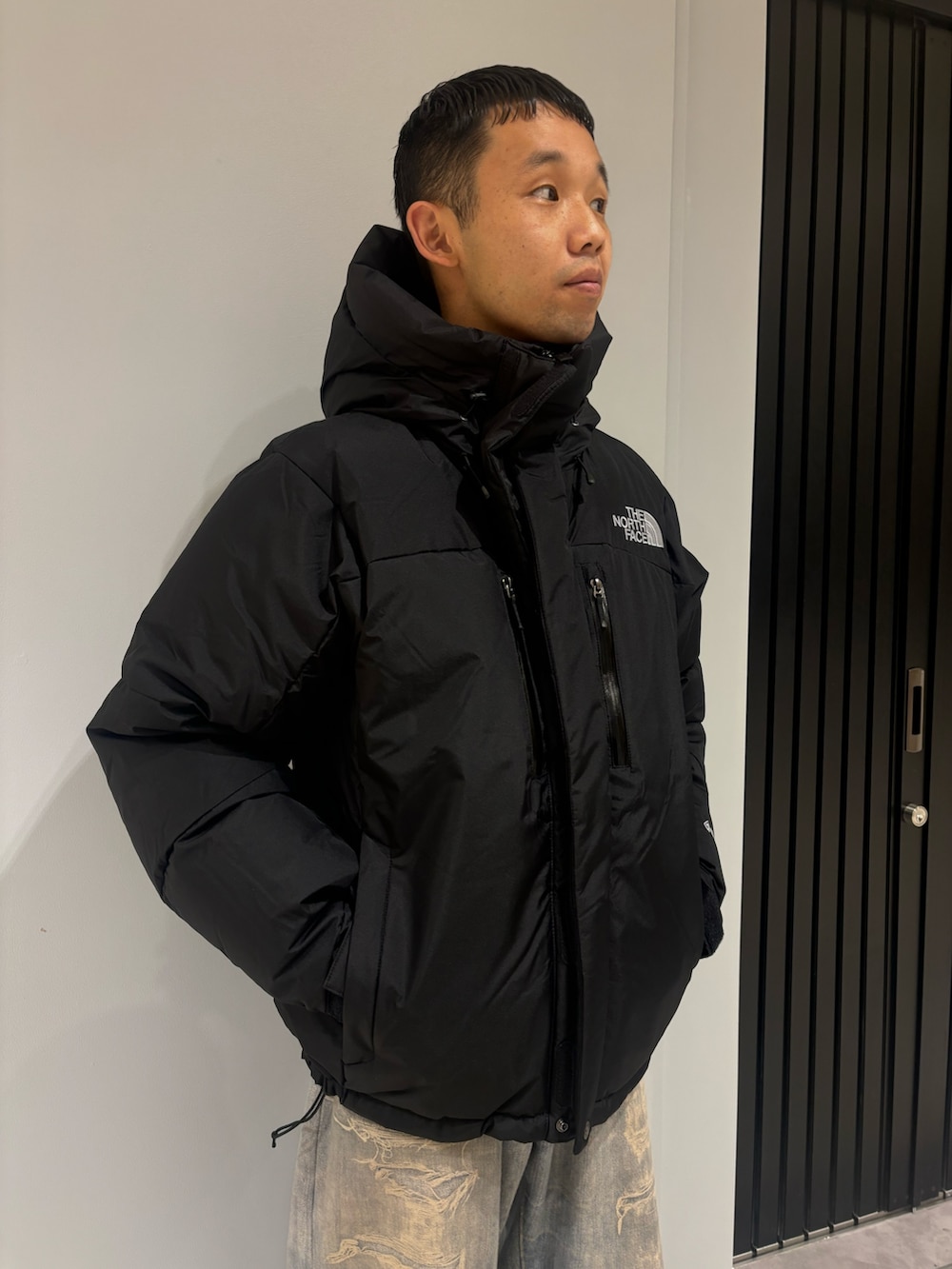 ブラック系のダウンジャケット/コート、その他のデニムパンツ、ベージュ系のサンダルを着用したメンズの冬コーディネートの3枚目の写真