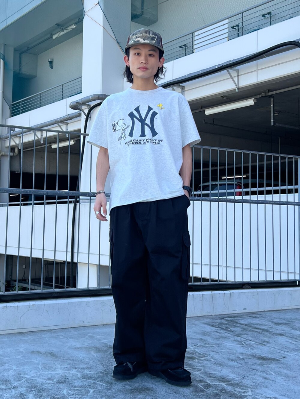 ブラック系のテーラードジャケット、グレー系のTシャツ/カットソー、ブラック系のカーゴパンツを着用したメンズの春コーディネートの2枚目の写真