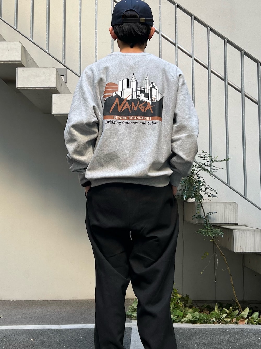 ベージュ系のダウンジャケット/コート、グレー系のスウェット、ブラック系のスラックスを着用したメンズの秋コーディネートの4枚目の写真