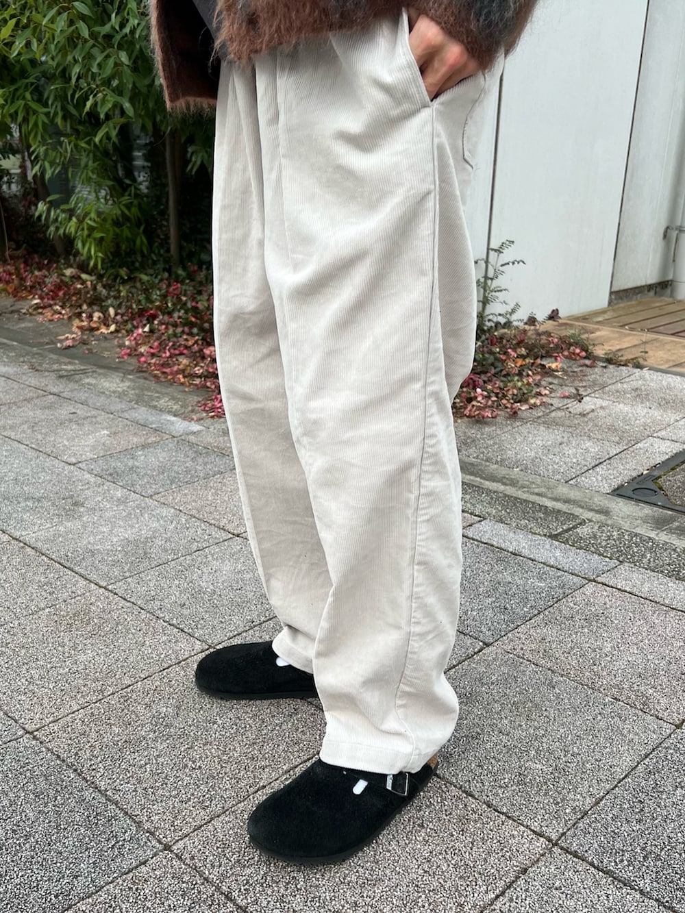 ブラウン系のニット/セーター、ブラック系のスウェット、ブラック系のサンダルを着用したメンズの冬コーディネートの3枚目の写真