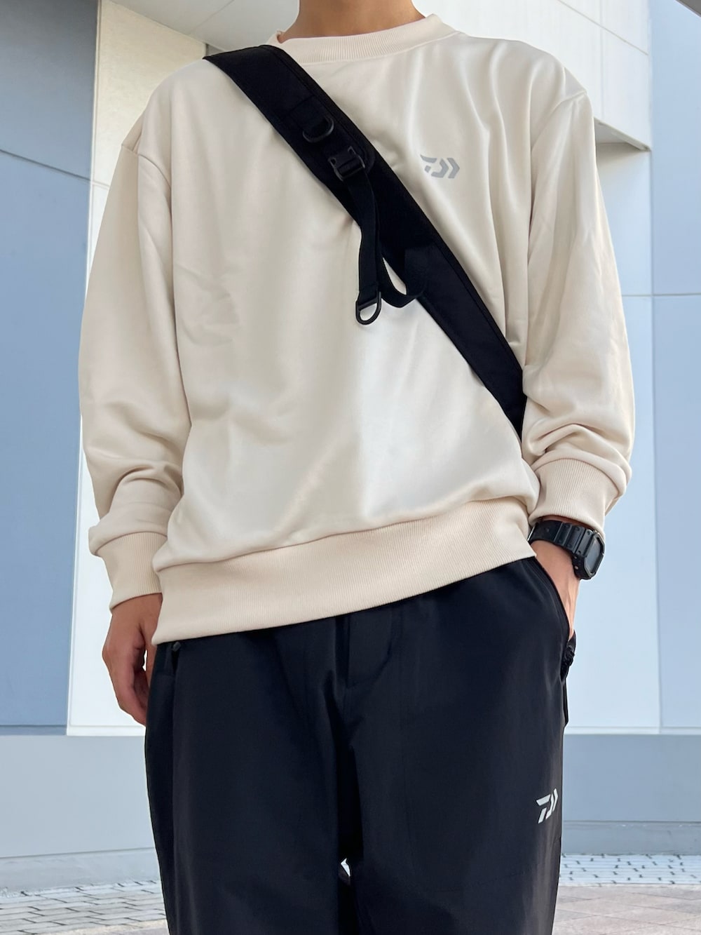 ブラック系のショルダーバッグ、ホワイト系のスウェット、ブラック系のサンダルを着用したメンズの秋コーディネートの3枚目の写真