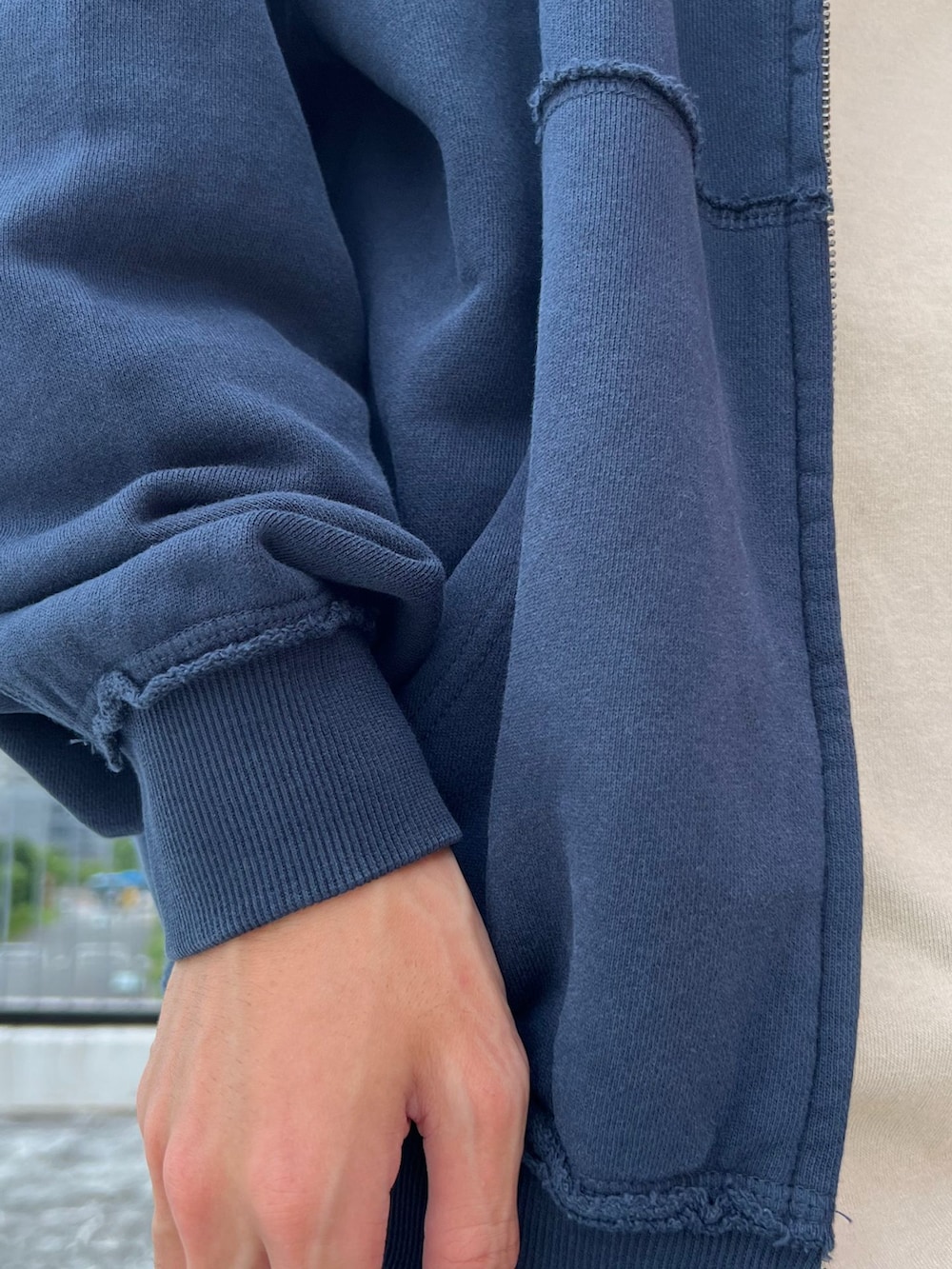 ブラック系のスラックス、ブルー系のカーディガン/ボレロ、ベージュ系のTシャツ/カットソーを着用したメンズの夏コーディネートの4枚目の写真