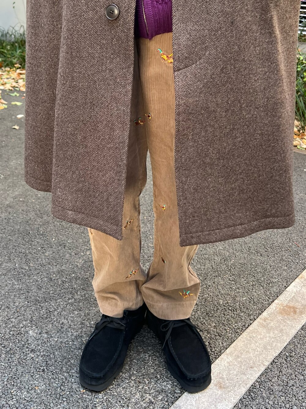 ブラウン系のステンカラーコート、パープル系のニット/セーター、ブラック系のモカシン/デッキシューズを着用したメンズの冬コーディネートの3枚目の写真