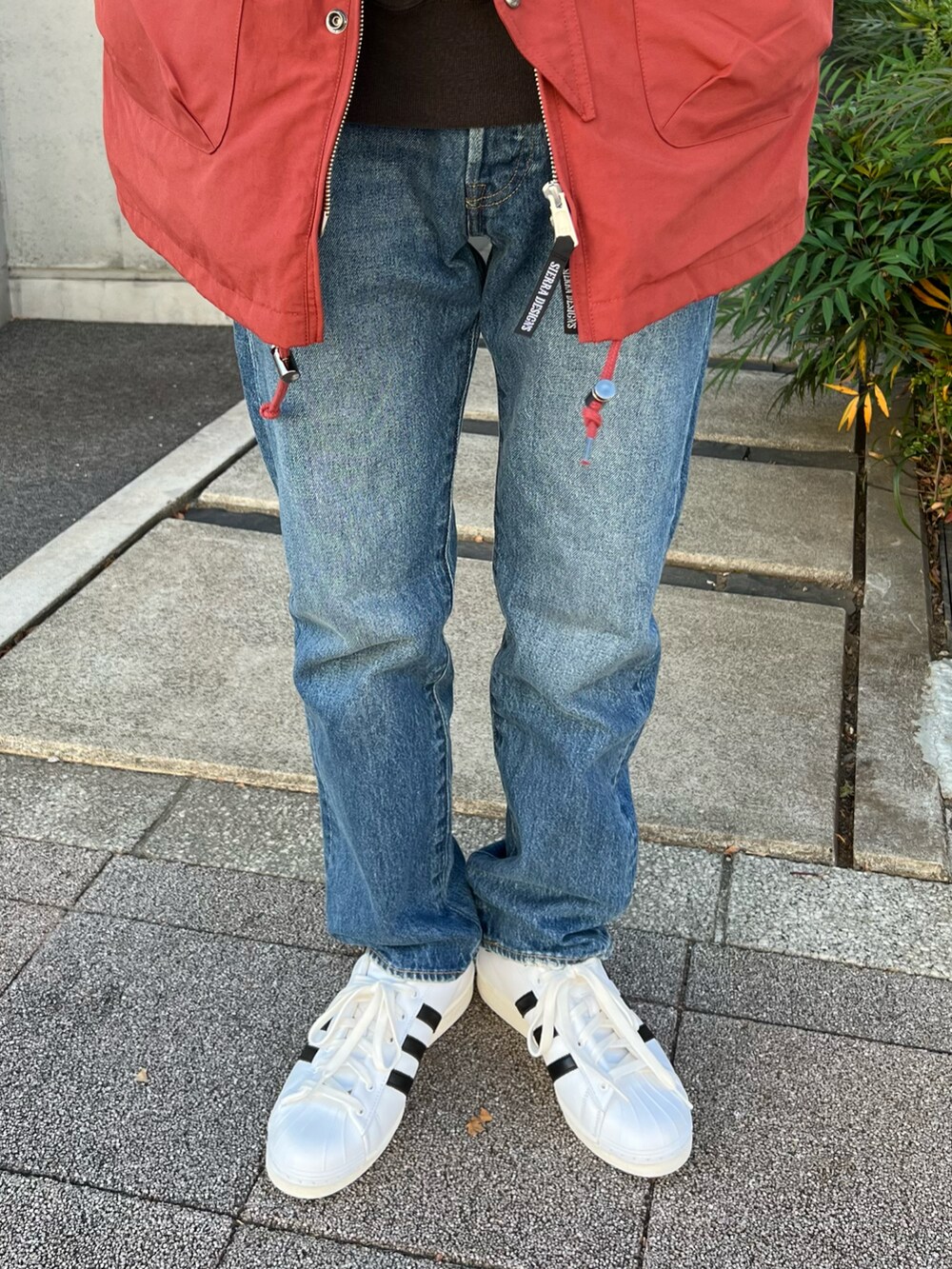 ブラック系のスウェット、ブルー系のデニムパンツ、ホワイト系のスニーカーを着用したメンズの冬コーディネートの3枚目の写真
