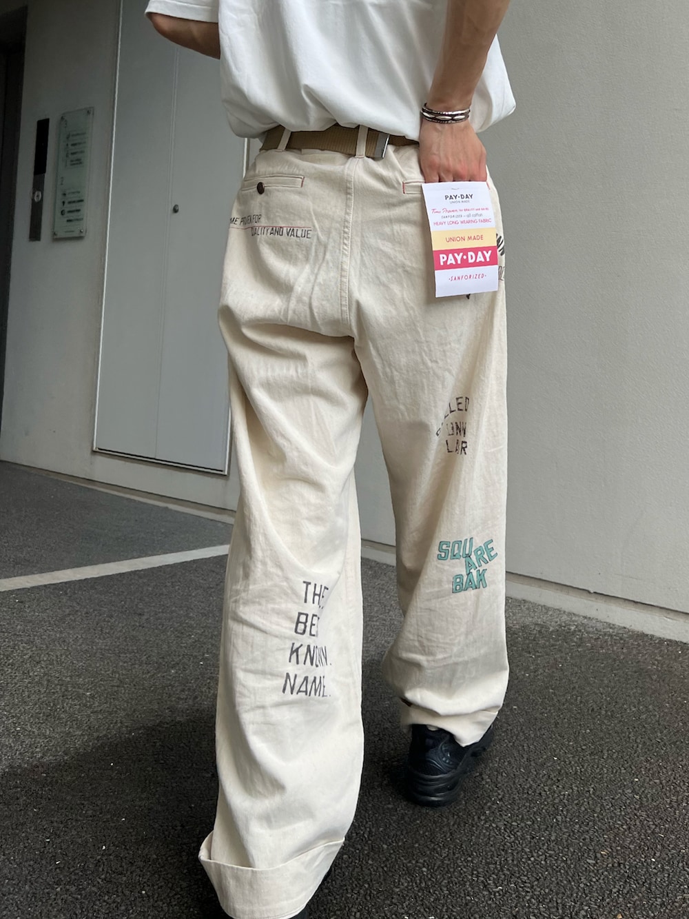 ホワイト系のTシャツ/カットソー、ホワイト系のその他パンツ、ブラック系のスニーカーを着用したメンズの夏コーディネートの3枚目の写真
