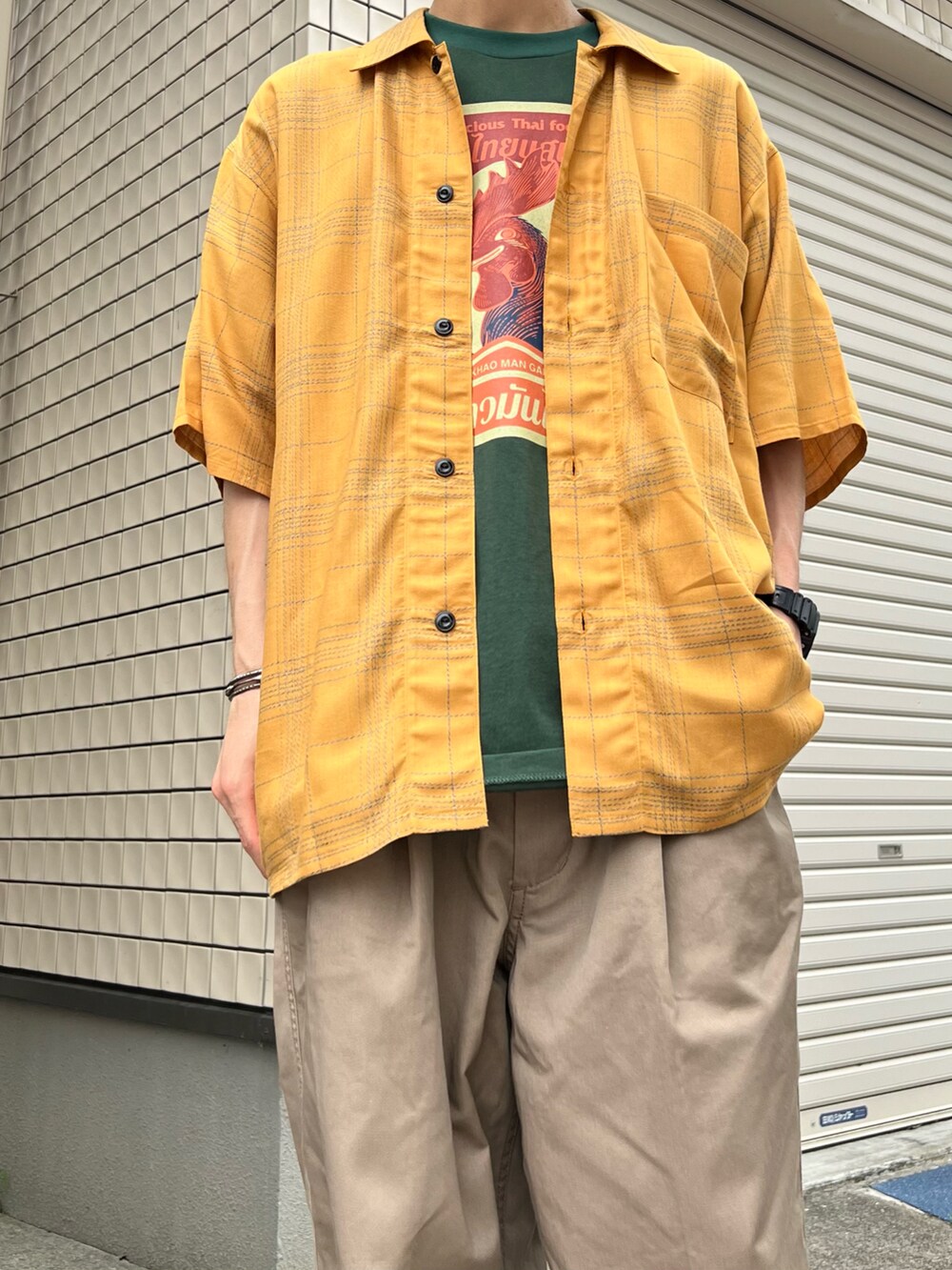 オレンジ系のシャツ/ブラウス、イエロー系のスラックス、ブラック系のその他シューズを着用したメンズの夏コーディネートの2枚目の写真