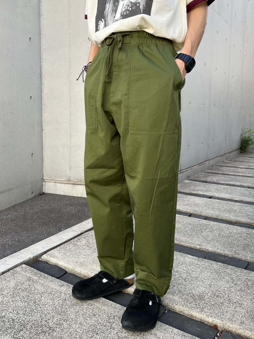 ホワイト系のTシャツ/カットソー、ブラック系のサンダル、グリーン系のその他パンツを着用したメンズの夏コーディネートの3枚目の写真