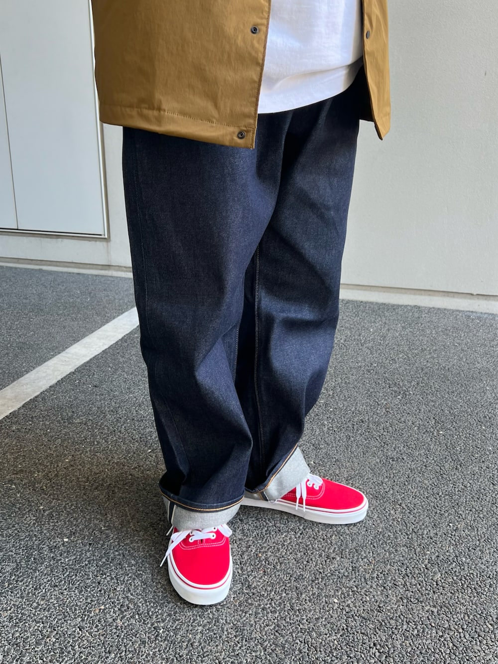 イエロー系のナイロンジャケット、ホワイト系のTシャツ/カットソー、レッド系のスニーカーを着用したメンズの夏コーディネートの2枚目の写真