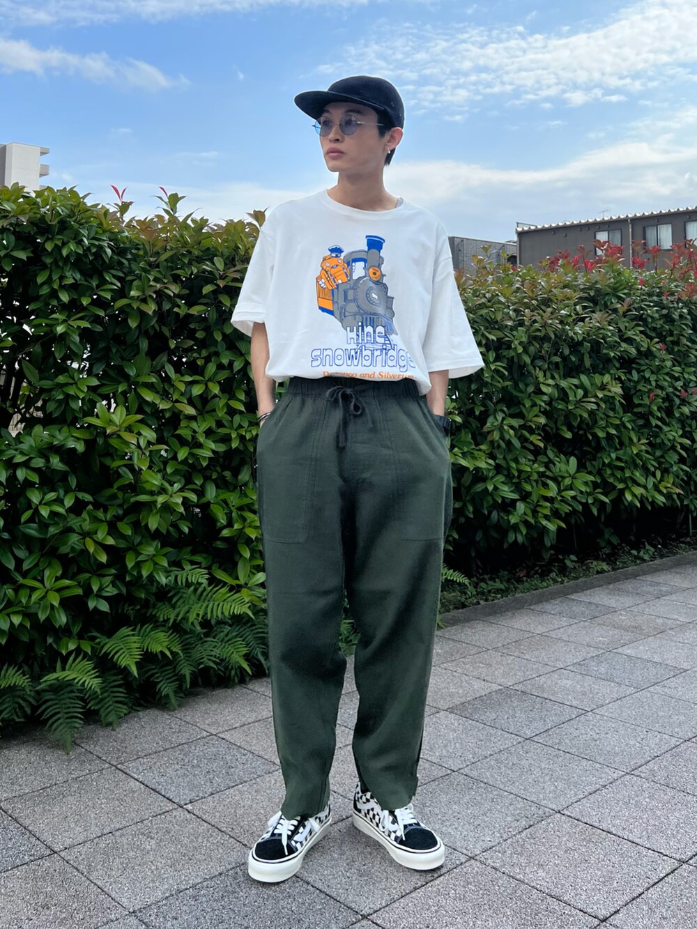 ホワイト系のTシャツ/カットソー、ブラック系のスニーカー、グリーン系のその他パンツを着用したメンズの夏コーディネートの3枚目の写真