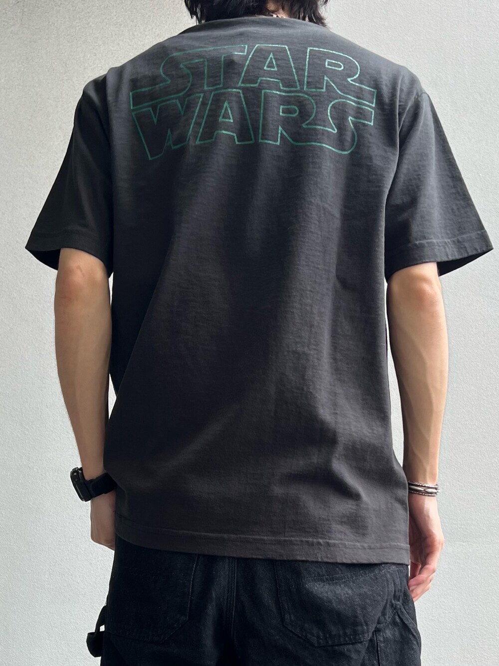 ブラック系のTシャツ/カットソー、ブラック系のサンダル、ブラック系のデニムパンツを着用したメンズの夏コーディネートの3枚目の写真