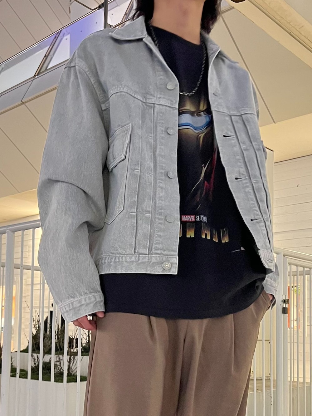 ベージュ系のスラックス、ブラック系のデニムジャケット、ブラック系のTシャツ/カットソーを着用したメンズの春コーディネートの3枚目の写真