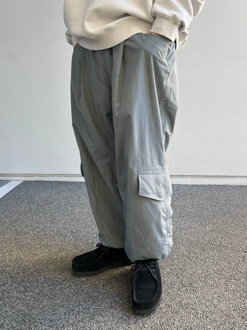 グレー系のカーゴパンツ、ブラック系のその他シューズ、ベージュ系のスウェットを着用したメンズの春コーディネートの3枚目の写真
