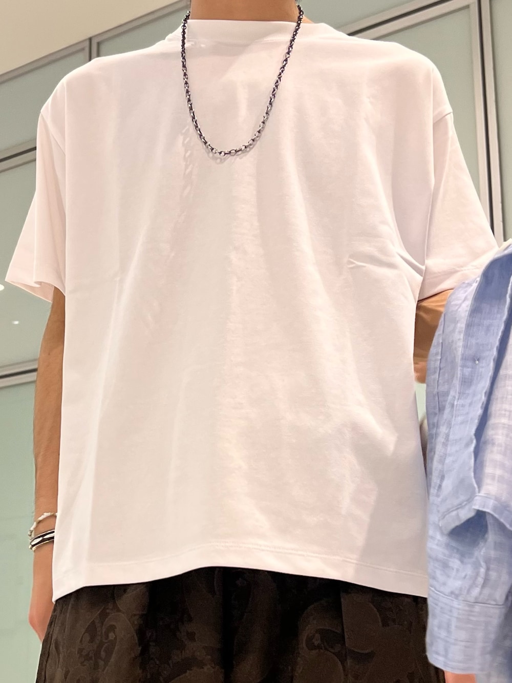 ホワイト系のTシャツ/カットソー、ブルー系のシャツ/ブラウス、ブラウン系のスラックスを着用したメンズの夏コーディネートの5枚目の写真