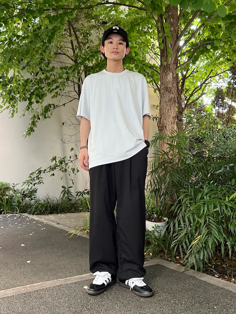 ブラック系のノーカラージャケット、ホワイト系のTシャツ/カットソー、ブラック系のスニーカーを着用したメンズの夏コーディネートの2枚目の写真