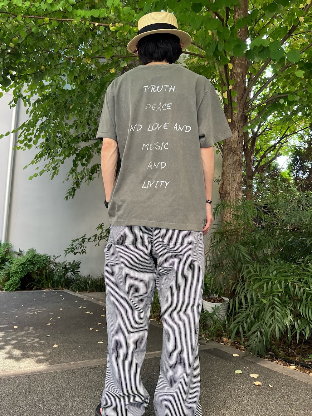 ブラック系のTシャツ/カットソー、ブルー系のデニムパンツ、ブラック系のサンダルを着用したメンズの夏コーディネートの3枚目の写真