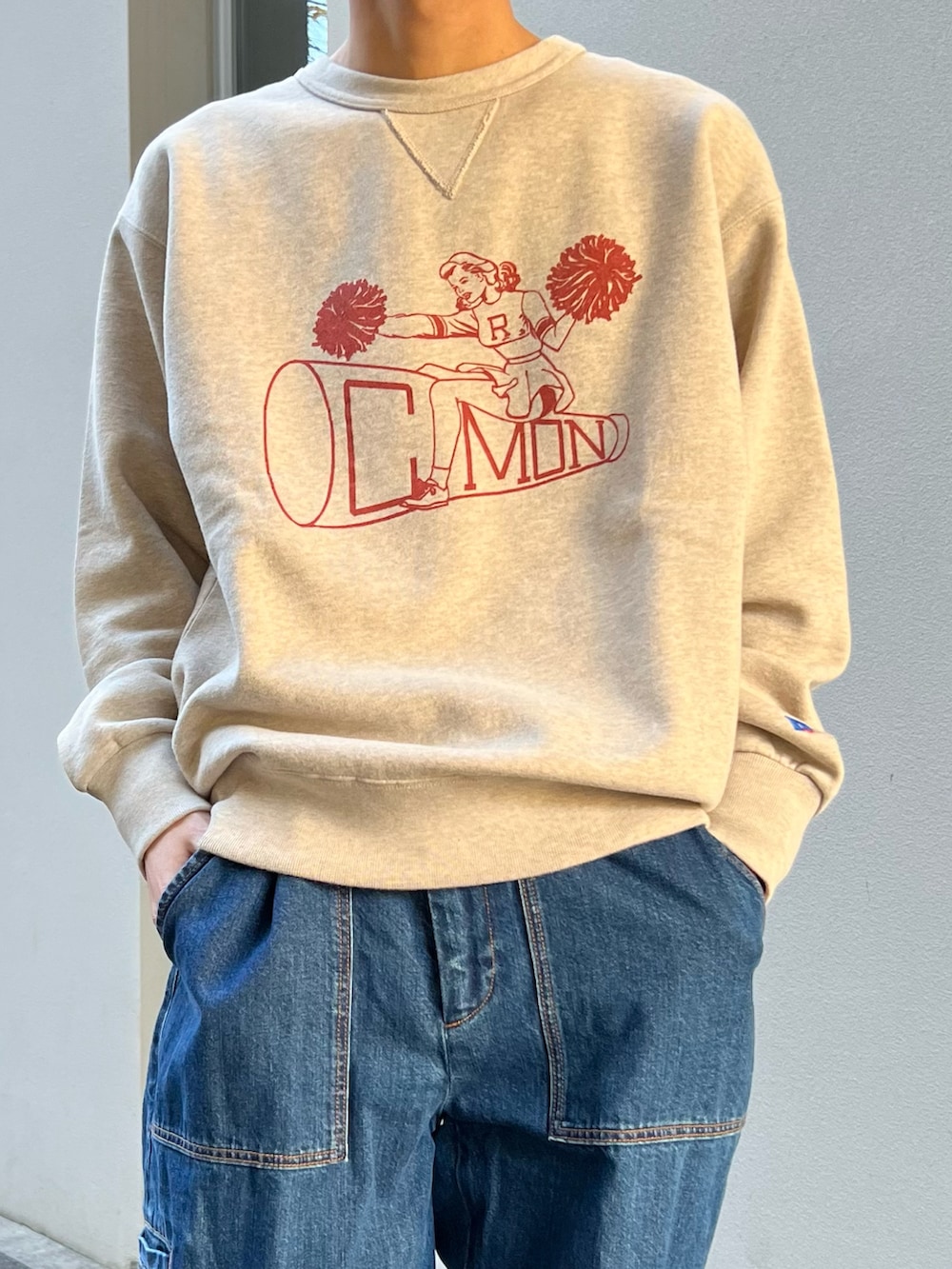 ベージュ系のスウェット、ブルー系のデニムパンツ、ブラック系のモカシン/デッキシューズを着用したメンズの冬コーディネートの2枚目の写真