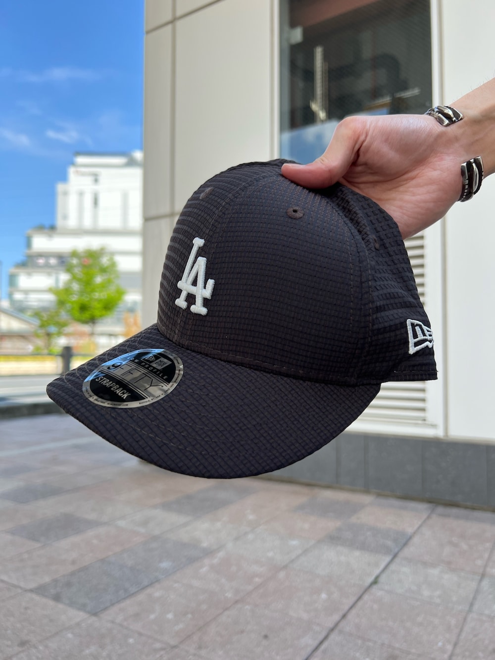 ホワイト系のTシャツ/カットソー、ブラック系のスニーカー、グレー系のスラックスを着用したメンズの春コーディネートの4枚目の写真