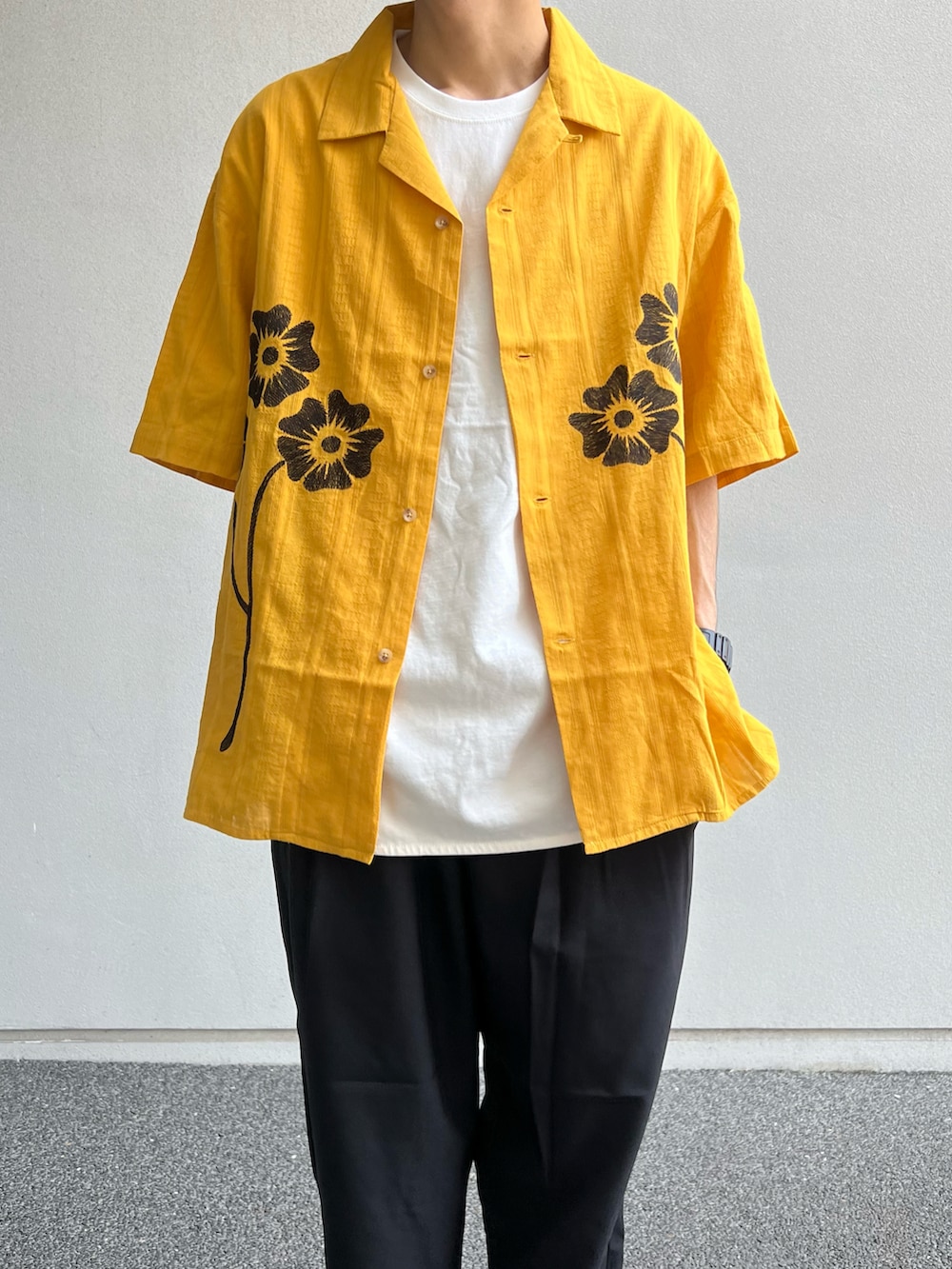 ホワイト系のTシャツ/カットソー、ブラック系のスラックス、ブラック系のスニーカーを着用したメンズの夏コーディネートの2枚目の写真