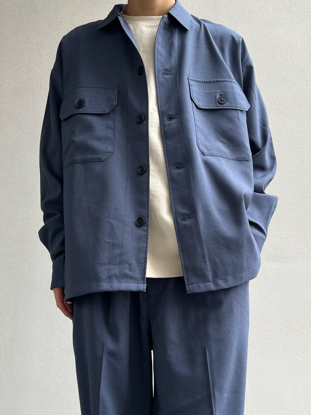ブルー系のシャツ/ブラウス、ホワイト系のTシャツ/カットソー、ブルー系のスラックスを着用したメンズの春コーディネートの2枚目の写真