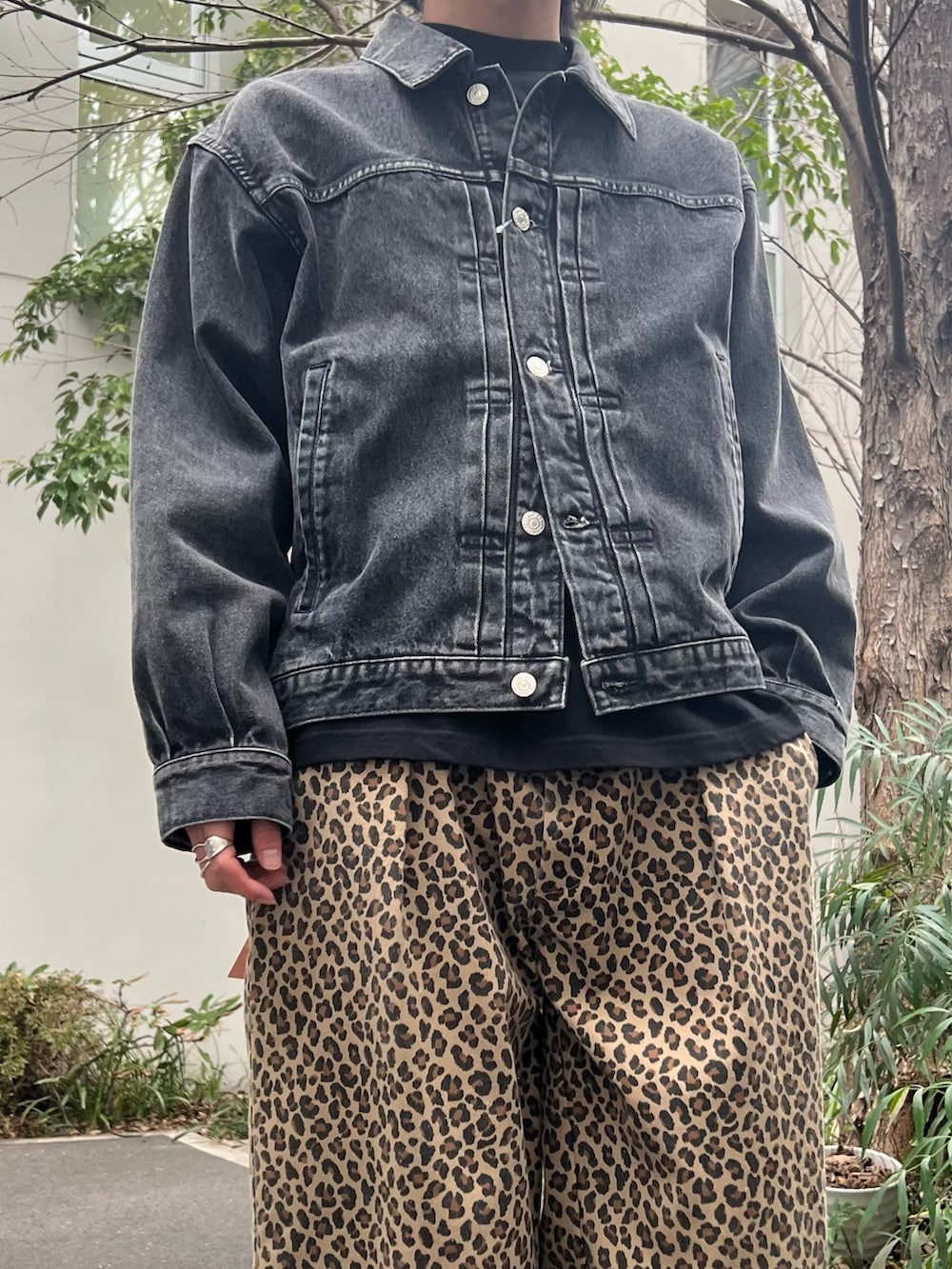 グリーン系のミリタリージャケット、ブラック系のデニムジャケット、イエロー系のチノパンツを着用したメンズの春コーディネートの4枚目の写真