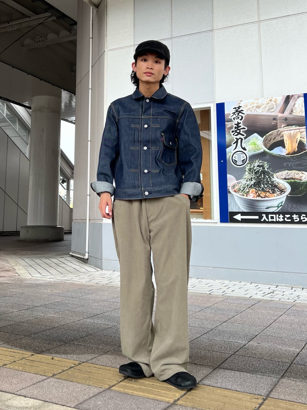 ピンク系のスウェット、ブルー系のデニムジャケット、ブラック系のサンダルを着用したメンズの秋コーディネートの2枚目の写真