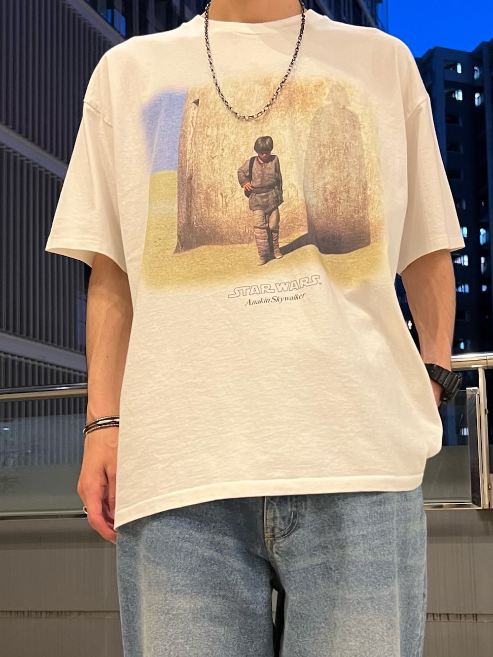 ホワイト系のTシャツ/カットソー、ブラック系のシャツ/ブラウス、ブルー系のデニムパンツを着用したメンズの春コーディネートの4枚目の写真