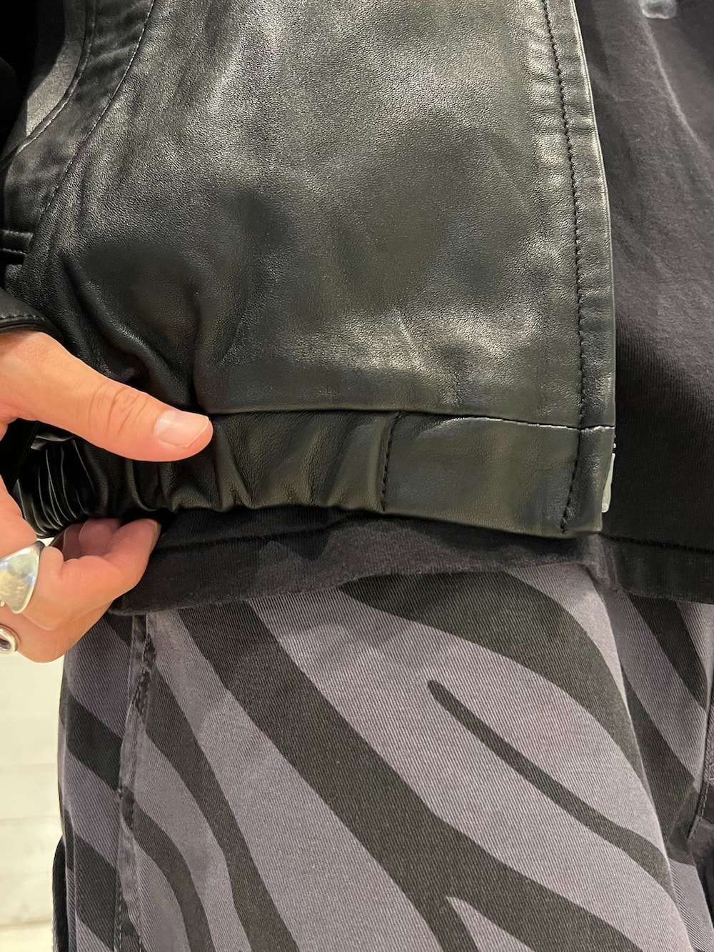 ブラック系のライダースジャケット、グレー系のその他パンツ、ブラック系のTシャツ/カットソーを着用したメンズの秋コーディネートの7枚目の写真
