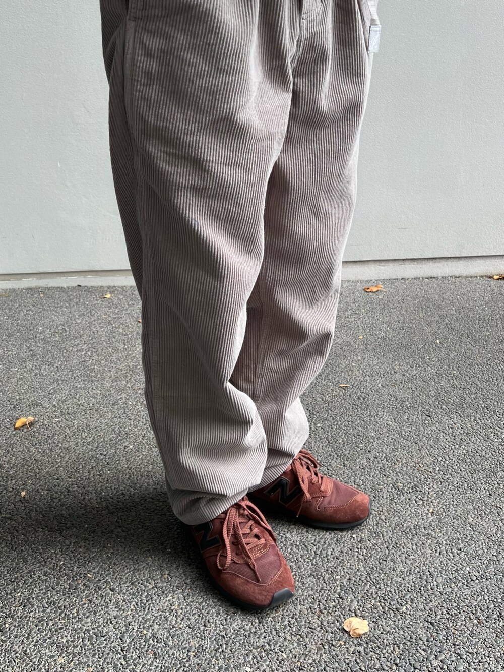 イエロー系のスウェット、グリーン系のダウンジャケット/コート、ブラウン系のスニーカーを着用したメンズの秋コーディネートの4枚目の写真