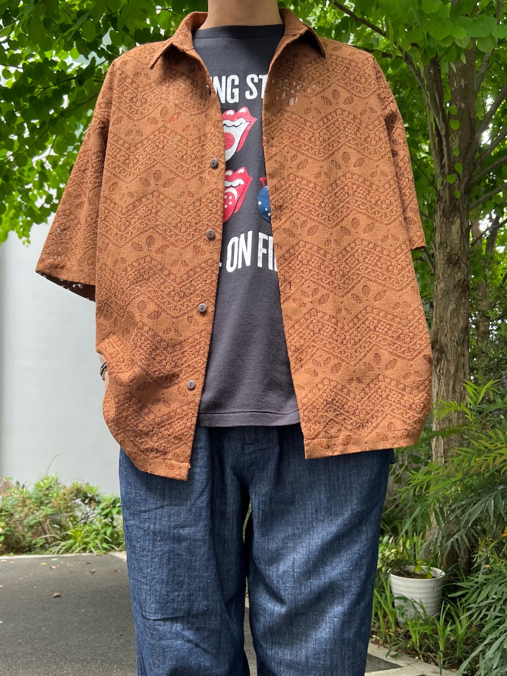 ブラウン系のシャツ/ブラウス、ブラック系のTシャツ/カットソー、ブルー系のデニムパンツを着用したメンズの春コーディネートの2枚目の写真