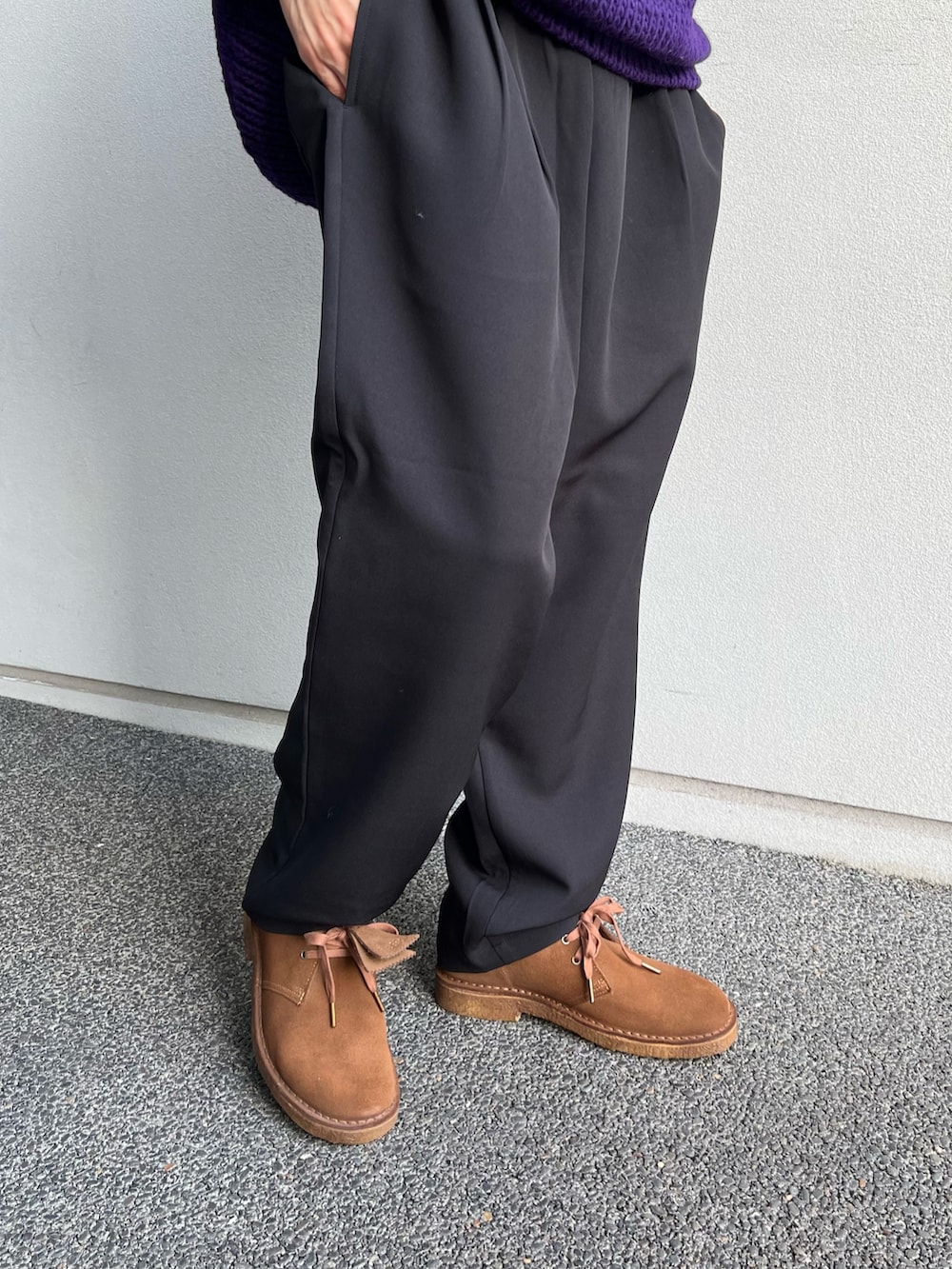 ブラック系のスラックス、パープル系のニット/セーター、ブラウン系のブーツを着用したメンズの冬コーディネートの3枚目の写真